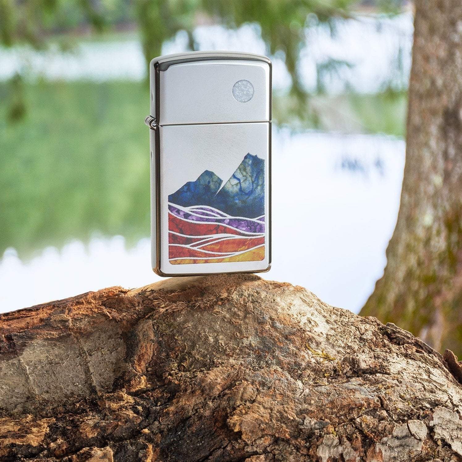 Lifestyle image of Slim® Landscape Design High Polish Chrome Windproof Lighter standing on a log in a forest.