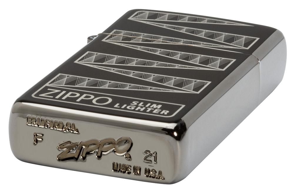 Slim® Black Ice® 65th Anniversary Collectible Windproof Lighter laying down at an angle, showing the front of the design and the unique bottom stamp.