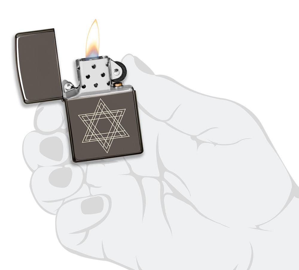 Star of David Design Black Ice® Windproof Lighter lit in hand.