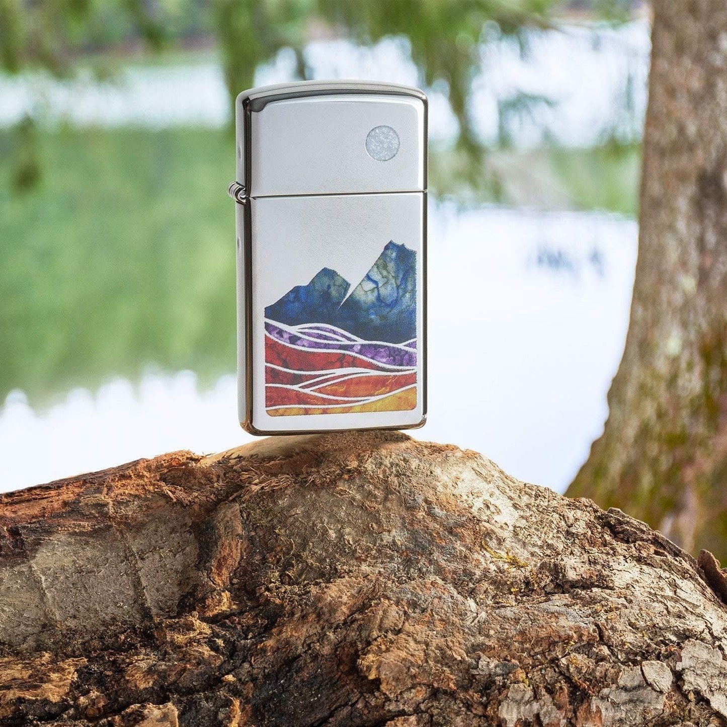Lifestyle image of Slim® Landscape Design High Polish Chrome Windproof Lighter standing on a log in a forest.